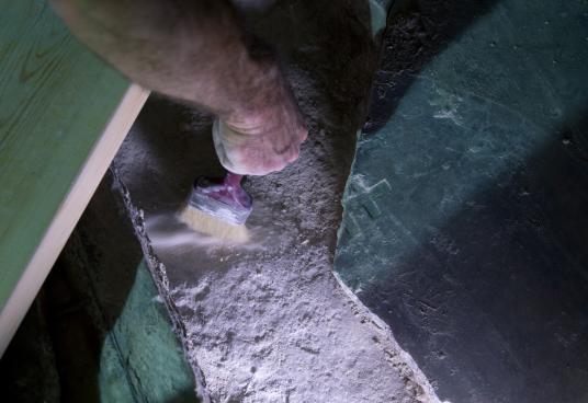 Реставратор премахва отломки под счупена мраморна плоча, за да разкрие оригиналната скална повърхността на това, което се смята за погребалното място на Иисус. 