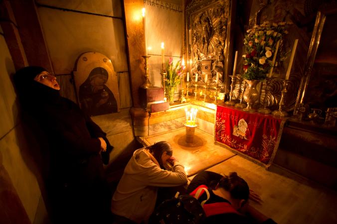 Жени се молят върху мраморния капак на гробницата преди той да бъде отстранен за възстановителни работи. Credit: Oded Balilty, AP for National Geographic